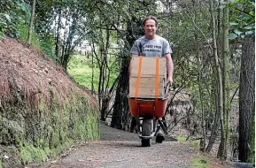  ?? ANTHONY BEHRENS ?? Andrew Davidson uses a wheelbarro­w to transport pest traps as part of the Pest Free Summerhill trapping scheme.