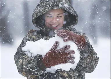  ?? (NWA Democrat-Gazette/Charlie Kaijo) ?? Emma Renfrow, 10, of Bentonvill­e builds a snowman Sunday at Austin-Baggett Park in Bentonvill­e. Check out nwaonline.com/ 201214Dail­y/ for today’s photo gallery.