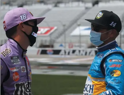  ?? PHOTOS BY CHRIS GRAYTHEN VIA NASCAR ?? Drivers Kyle Busch, left, and Clint Bowyer talk prior to the NASCAR Cup Series race at Atlanta on Sunday. Busch finished second to Kevin Harvick.