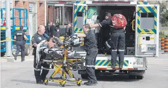  ?? BOB TYMCZYSZYN THE ST. CATHARINES STANDARD ?? A person is taken away by Niagara Emergency Medical Services as Niagara Regional Police were searching for suspects after a shooting in the downtown area of St. Catharines.