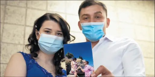  ?? MICHAEL GARD/POST-TRIBUNE PHOTOS ?? Lubica Trenoski, of Crown Point, and her fiance, Ivan Petreski, of Macedonia, display the photo of their engagement in Macedonia before getting married at the Lake County Courthouse on Friday. The couple connected on Facebook in 2016.