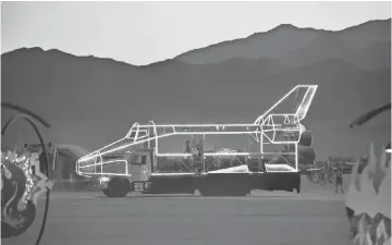  ?? TREVOR HUGHES, USA TODAY ?? An illuminate­d vehicle resembling the space shuttle rolls across the desert at Burning Man.