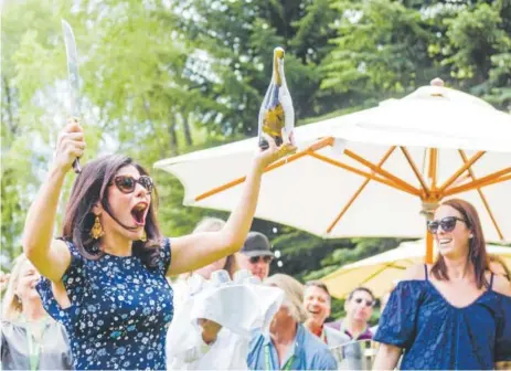  ?? Photos by Greg McBoat, Special to The Denver Post ?? Nilou Motamed sabers champagne at the AmEx Trade Lunch.