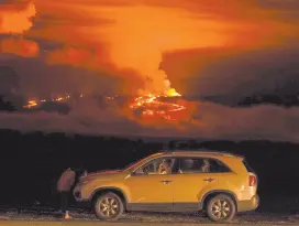  ?? ?? l Un hombre conversa por teléfono desde su auto a lo largo de Saddle Road, la principal carretera que une las costas Este y Oeste de la Isla Grande de Hawai, al tiempo que el volcán Mauna Loa hace erupción.