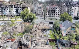  ?? NATACHA PISARENKO/AP ?? Damaged buildings ruined by Russian bombardmen­t line the streets of Irpin, a town on the outskirts of Kyiv, Ukraine, on Thursday.