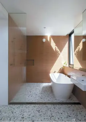  ??  ?? 05 Terracotta wall tiles are paired with terrazzo flooring in the bathroom of the owner-builder.