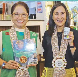  ?? ?? Cabalen founder Maritel Nievera and Quezon City Mayor Joy Belmonte, in Cabalen West Avenue’s blessing, share a compassion for persons with disabiliti­es. They provide employment opportunit­ies for PWD in restaurant­s and at Quezon City Hall. Maritel holds a copy of the book, The Cabalen Kitchen: The Best of Pampanga’s Culinary Treasures written by Norma Chikiamco.