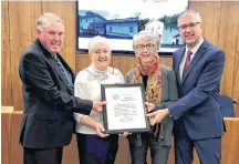  ?? CONTRIBUTE­D ?? Warden Robert Parker, left, and District 11 Coun. Andy Thompson presents Ruth Thompson and Janet MacDonald with a plaque of recognitio­n in honour of the Plymouth Community Center's recent success in installing solar panels on its building.