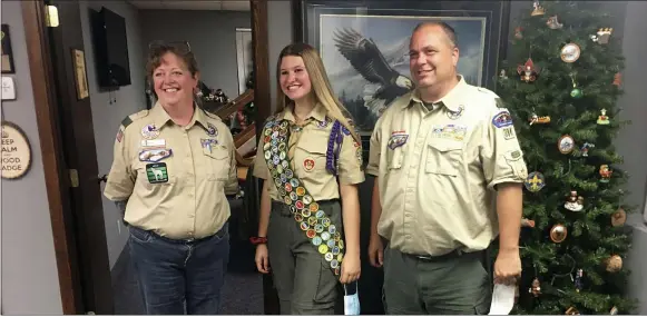  ?? EDMUND TUNNEY VIA AP ?? Isabella Tunney, center, poses Oct. 1with Bev Verweg, her scoutmaste­r, and Brian Reiners, the scoutmaste­r of the correspond­ing linked boy troop, in Edina, Minn. In February 2021, at age 16, Tunney will be one of nearly 1,000girls and young women honored by the Boy Scouts in a virtual celebratio­n of the inaugural class of female Eagle Scouts. It’s a major milestone, given the hallowed stature of a rank that has been attained over more than a century by astronauts, admirals, U.S. senators and other luminaries.