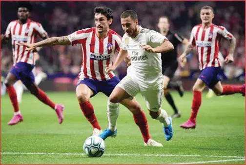  ??  ?? Eden Hazard (in white) could not help Madrid overcome Atletico but his team stays top