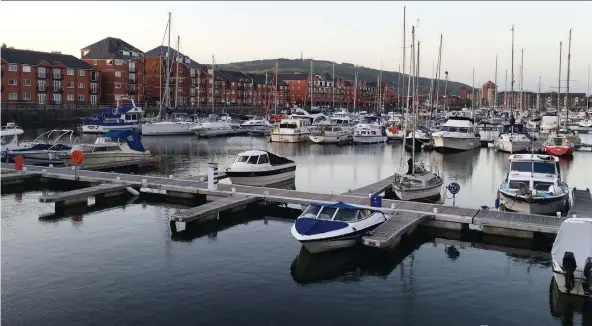  ?? LANCE HORNBY ?? Vintage crafts are moored next to shops and restaurant­s at Swansea marina, on the south coast of Wales.