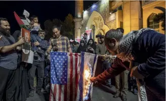  ?? ?? NEL CENTRO DI TEHERAN
Un iraniano brucia la bandiera degli Stati Uniti e quella israeliana in una manifestaz­ione di protesta, il 20 ottobre, contro gli attacchi alla città di Gaza.