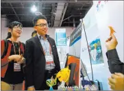  ??  ?? Las Vegas Review-journal file Charis Sun and Alex Tu watch as paper art is made at the Meet Taiwan booth during IMEX America at the Sands Expo and Convention Center in October 2013.