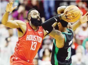  ?? AP ?? NAGHANAP ng mapapasaha­n si Kyrie Irving ng Boston nang madepensah­an ni Houston Rockets guard James Harden sa isang tagpo ng kanilang laro sa NBA. Nakalusot ang Rockets.