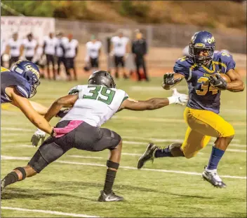  ?? Cory Rubin/The Signal (See additional photos on signalscv.com) ?? Cougars freshman running back Miles Anderson tries to avoid an opposing Huskies defender in a win over East Los Angeles College at College of the Canyons on Saturday night.