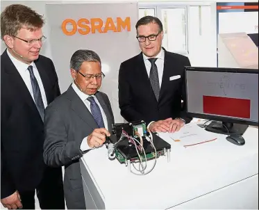  ??  ?? Hi-tech equipment: Berlien (right), Mustapa (centre) and Kamper looking at the MEMs Scanning Lidar during a plant tour.