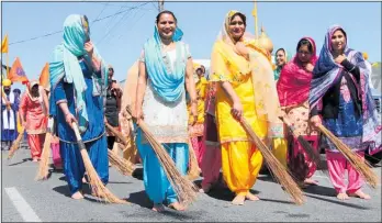  ?? PHOTOS / STUART WHITAKER ?? ABOVE: Sewadars sweep the road ahead of the parade.