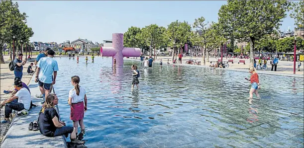  ?? Fotos: ROBIN UTRECHT y ALEX HALADA/AFP ?? • En Ámsterdam, las personas se pasean en la fuente de la plaza del Barrio de los Museos, pese a la advertenci­a de permanecer en sus casas.