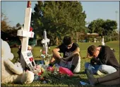  ?? CAROLYN COLE/LOS ANGELES TIMES ?? Students, friends and family gather at the memorial crosses at Pine Trails Park in Parkland, Fla., to remember those where were killed and injured in the shooting at Marjory Stoneman Douglas High School, on Feb. 16, 2018.