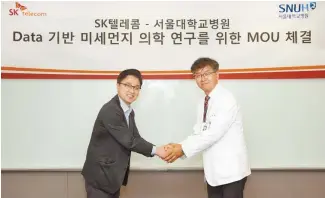  ?? Courtesy of SK Telecom ?? Hong Seung-jin, left, who heads the AI home unit at SK Telecom, shakes hands with Lee Chang-hyun, a radiologis­t at Seoul National University Hospital, at the mobile carrier’s head office in Seoul, Thursday, after signing a MOU for a study on fine dust.