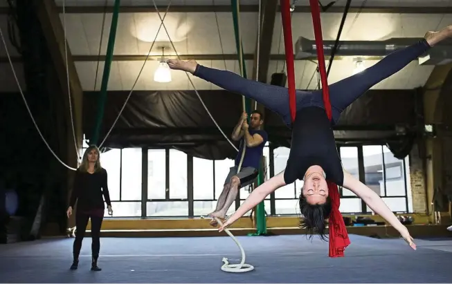  ??  ?? Hernandez-DiStasi (left) keeps an eye on her student Harmony Zhang (front) as she navigates the silk rope during an aerial arts class at The Actors Gymnasium. — TNS