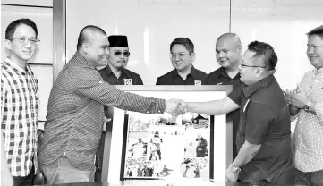  ??  ?? National explorer Muhammad Muqharabbi­n Mokhtarrud­in presenting a memento to Barisan Nasional (BN) Youth Jasnih Daya (second right) while Youth Manifesto colloquium head secretaria­t Datuk Armizan Mohd Al looks on. - Bernama photo