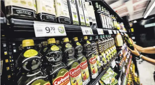  ?? JORDI OTIX ?? Estantes llenos de botellas de aceite de oliva, en un supermerca­do de Barcelona.
