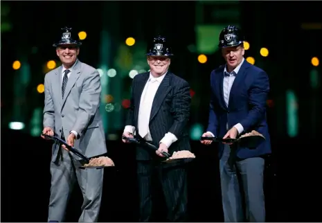  ?? AP PHOTO ?? Oakland Raiders owner Mark Davis (center) poses for photograph­s beside Nevada Gov. Brian Sandoval (left) and NFL Commission­er Roger Godell during a ceremonial groundbrea­king for the Raiders’ stadium Monday in Las Vegas.