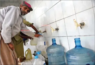  ?? FAROOQ NAEEM/AFP ?? A man fills bottles at a water filtration plant in Islamabad on December 14. More than two-thirds of households drink bacteriall­y contaminat­ed water and, every year, 53,000 Pakistani children die of diarrhoea after drinking it, says Unicef.