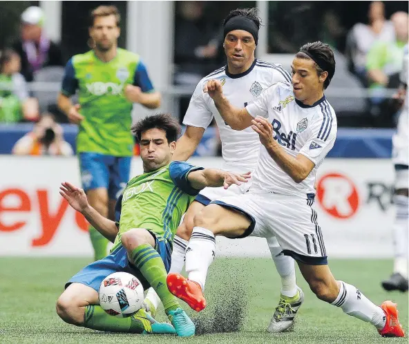  ?? — AP FILES ?? Vancouver Whitecaps midfielder Christian Bolanos, centre, and forward Nicolas Mezquida, right, were likely candidates to fill coach Carl Robinson’s playmaking role in the 4-2-3-1 formation. But Bolanos is dealing with a knee injury, while Mezquida has...