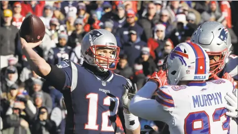  ?? Steven Senne / Associated Press ?? New England Patriots quarterbac­k Tom Brady passes under pressure from Buffalo defensive end Trent Murphy on Sunday in Foxborough, Mass.