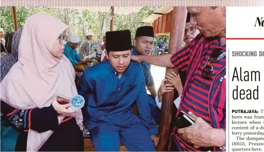  ?? PIX BY ZAMAN HURI ISA ?? Relatives comforting Wan Mohd Fauzul Azam Wan Mohd Rais at the Mukim Bukit Gading cemetery in Tanah Merah yesterday.