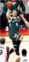  ?? Associated Press ?? Milwaukee Bucks guard Matthew Dellavedov­a looks for a shot under pressure from Toronto Raptors defenders Tuesday during the first half of a first-round playoff series in Toronto.