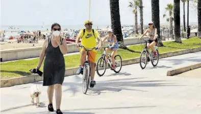  ?? GABRIEL UTIEL ?? Varias personas pasean y circulan en bicicleta junto a la playa de l’Almadrava de la localidad de Benicàssim.