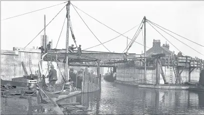  ?? Photo by Mirrorpix www.buyaphotot­ms.co.uk 041214dolp­hin ?? n WORK IN PROGRESS: Workmen rebuilding the Dolphin Bridge over the Grand Union Canal in Uxbridge around 1929