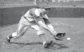  ?? Paul Cannon
Associated Press ?? CUBS’ OLDEST ALUMNUS Chicago Cubs shortstop Lennie Merullo fields a ball in April 1942. He made his Chicago debut in1941 and played until 1947. He had a career batting average of .240 and hit six home runs.