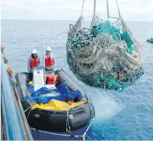  ?? MATT SAUNTER, PAPAHANAUM­OKUAKEA MARINE DEBRIS PROJECT VIA AP ?? Joao Garriques, left, and Matthew Chauvin load fishing nets onto a ship near Kure Atoll in the Northweste­rn Hawaiian Islands on April 11.