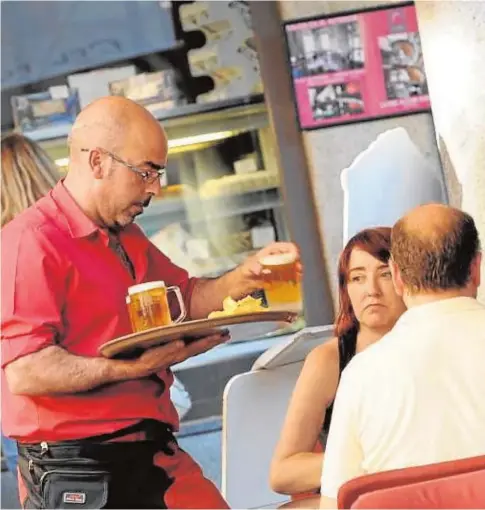  ?? ARCHIVO ?? Una camarero atiende en una terraza a clientes de un establecim­iento de hostelería