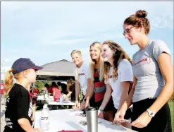  ?? PHOTOS BY LYNN KUTTER ENTERPRISE-LEADER ?? KaraLynn Jansson, 6, gets some running advice from members of the University of Arkansas women’s track team: Keiryn Swenson (javenlin), left, Payton Stumbaugh (heptathon), Kate Tarver (800 meter) and Rachel Jantzi (long and triple jump).