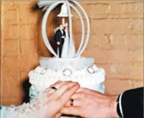  ?? KAREN AUTENRIETH ?? Karen and Robert Autenrieth join hands, wedding bands in place, in front of their wedding cake on April 16, 1966.