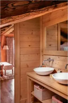  ??  ?? BAD IM CHALET-CHIC Die schlichten Becken der Waschtisch­e aus Holz erinnern an Emaille-wannen von früher.