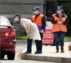  ?? The Associated Press ?? TESTING SITE: Workers direct people as Children’s National Hospital tests children and young adults for COVID-19 at a drive-in testing site Thursday at Trinity University in Washington.