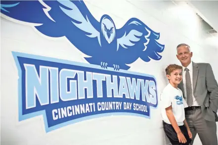  ?? AMANDA ROSSMANN/CINCINNATI ENQUIRER ?? Nathan and Aaron Kellenberg­er are a father and son duo who were on the mascot committee at Cincinnati Country Day School to help determine the school’s new mascot. Nathan, 10 and his father, Aaron, the director of enrollment management are photograph­ed with the new Nighthawks logo at Cincinnati Country Day School on Monday.