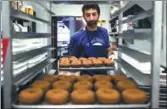  ?? AP ?? Matt Fein prepares doughnuts for a Phish concert at Federal Donuts in Philadelph­ia. The band works each night’s custom flavor into its setlists.