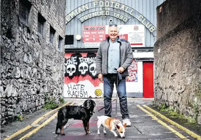  ?? PHOTO: STEVE HUMPHREYS ?? The place to be: Campbell Spray with his dogs Dooey and Ziggy outside Dalymount Park in Phibsborou­gh on Dublin’s north side.