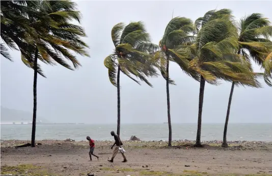  ?? PHOTO AFP ?? Deux marcheurs bravaient hier un vent violent à Cap-Haïtien, ville située au nord d’Haïti, où l’ouragan Irma menaçait de frapper.