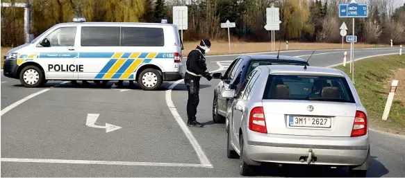  ?? Foto: Stanislav Heloňa, MAFRA ?? Stát! Policista zastavuje auta na dálničním sjezdu silnice D35 u Litovle. Hygienici nařídili celé město zcela uzavřít. Nikdo nesmí ven ani dovnitř.