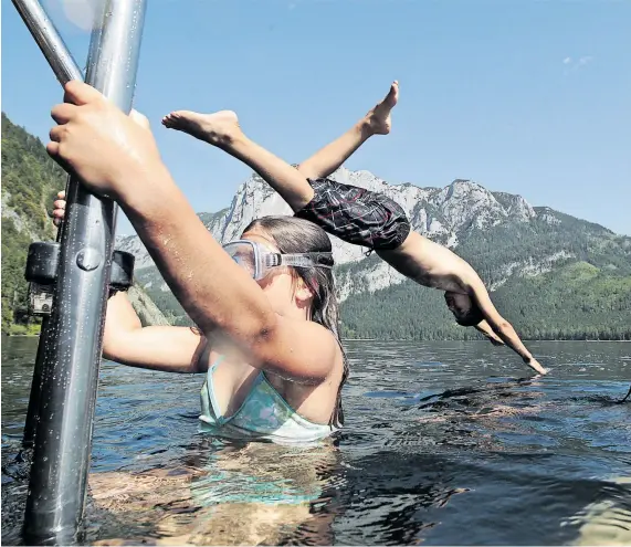  ?? Reuters ?? Glücklich, wer einen Platz an den Seen ergattert: Mitunter sind diese in den Strandbäde­rn heuer streng limitiert.