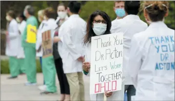  ?? BARBARA J. PERENIC/THE COLUMBUS DISPATCH VIA AP ?? Dozens don masks along with scrubs and white coats as the Physicians Action Network held a public rally in support of Dr. Amy Acton at the Ohio Statehouse in downtown Columbus May 3.