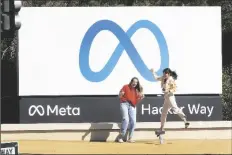  ?? AP PHOTO/ TONY AVELAR ?? Facebook employees take a photo with the company’s new name and logo outside its headquarte­rs in Menlo Park, Calif., Thursday after the company announced that it is changing its name to Meta Platforms Inc.